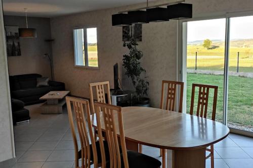 - une salle à manger avec une table, des chaises et un canapé dans l'établissement Maison entière de plein pied avec vue panoramique., à Venteuges