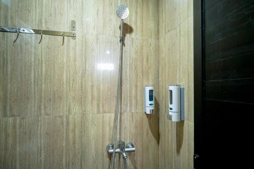 a shower with a shower head in a bathroom at Sans Bougenville Lampung in Lampung