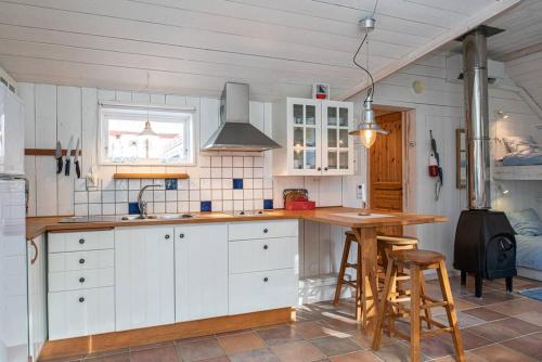 a kitchen with white cabinets and a wooden counter top at Seaside Cottage Nr 3, Saltvik Hudiksvall in Hudiksvall