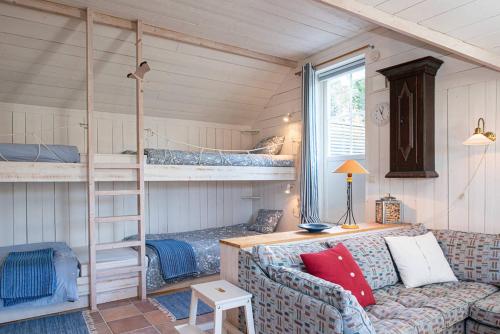 a living room with a couch and bunk beds at Seaside Cottage Nr 3, Saltvik Hudiksvall in Hudiksvall