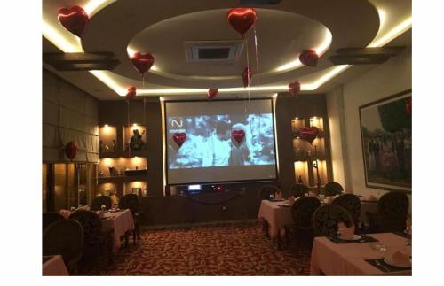 a room with a large screen in a restaurant at Abu Sanaa Hotel in As Sulaymānīyah