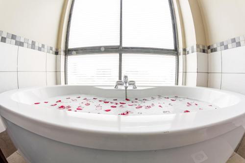 a white bath tub with roses on it in front of a window at Hotel Rio in Nairobi