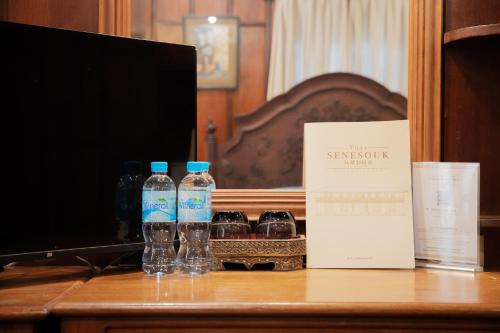 two bottles of water sitting on top of a desk at Villa Senesouk Luang Prabang in Luang Prabang