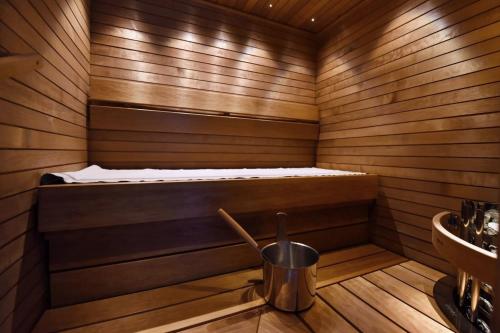 a sauna with a bed and a bucket in it at Levin Alppitalot Alpine Chalets Deluxe in Levi