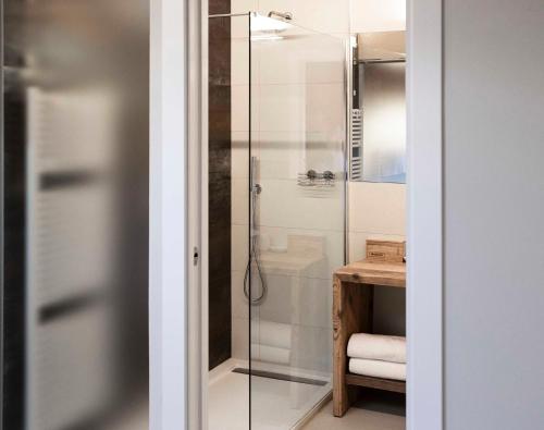 La salle de bains est pourvue d'une douche avec une porte en verre. dans l'établissement Corte Massimago, à Mezzane di Sotto