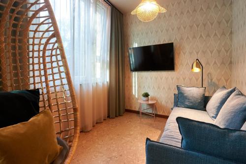 a living room with a couch and a tv in a room at Cocoon Sendlinger Tor in Munich