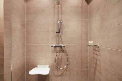 a bathroom with a shower with a toilet and a sink at Hotel Indigo - Dusseldorf - Victoriaplatz by IHG in Düsseldorf