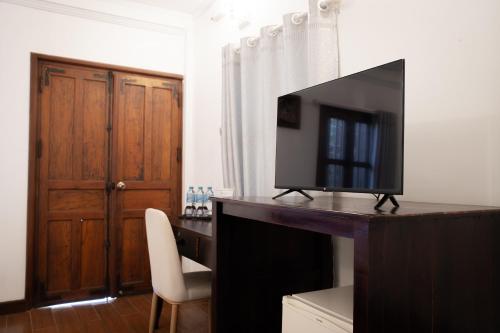 a television sitting on top of a desk in a room at Villa Senesouk Luang Prabang in Luang Prabang