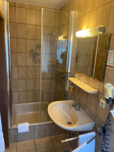 a bathroom with a shower and a sink and a tub at Gästehaus Veronika in Altenberge