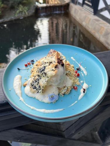 a piece of cake on a blue plate on a table at Podu' cu Lanturi in Bacău