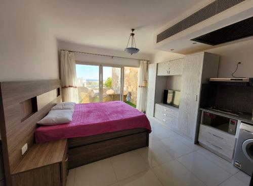 sypialnia z fioletowym łóżkiem i telewizorem w obiekcie Luxury suite for rent in Sahl Hasheesh w mieście Hurghada