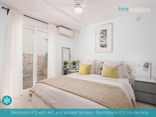 1 dormitorio blanco con 1 cama grande con almohadas amarillas en Villa Serenity - HMR Holidays, en Moraira