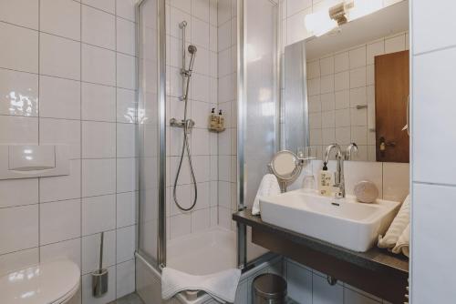 a bathroom with a sink and a shower and a toilet at Der Gollinger in Saalbach Hinterglemm