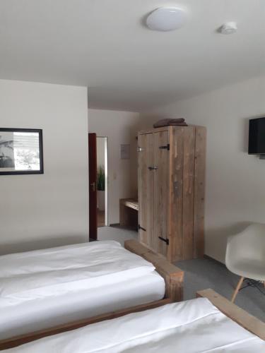 メーデバッハにあるPension Orketalのベッドルーム1室(ベッド2台、木製キャビネット付)