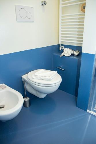 a blue bathroom with a toilet and a sink at Easy Milano - Rooms and Apartments Navigli in Milan
