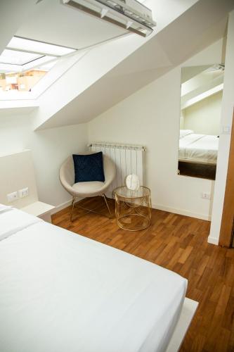 a bedroom with a bed and a chair and a mirror at Easy Milano - Rooms and Apartments Navigli in Milan