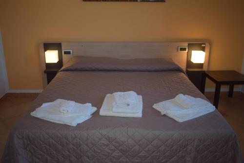 a bedroom with a bed with towels on it at Bed & Bike in Volterra