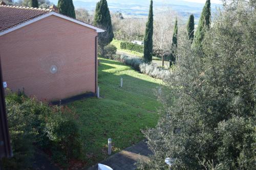 a view of a yard with a building and trees at Bed & Bike in Volterra