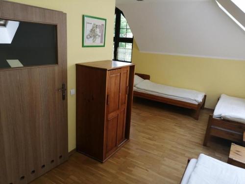 Habitación con TV y puerta de madera. en Muzeum Archeologiczne w Biskupinie - Dom Muzealnika, en Biskupin