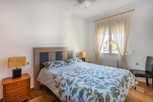 um quarto com uma cama, uma cadeira e uma janela em 5 bedroom Villa private pool em Playa Flamenca