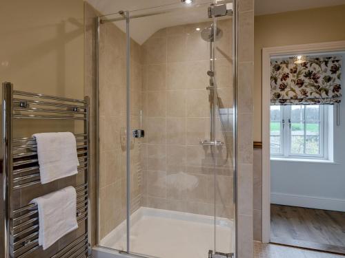 a bathroom with a shower with a glass door at Wisteria House in Henstead