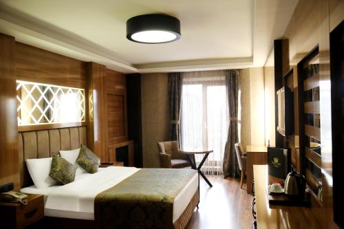a hotel room with a bed and a window at Gumus Palace Suites in Istanbul