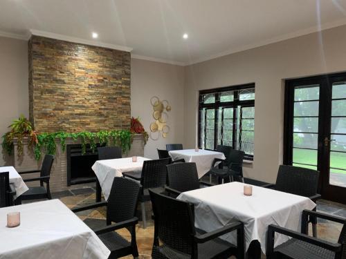 a dining room with tables and chairs and a fireplace at The Midlands Hotel in Pietermaritzburg