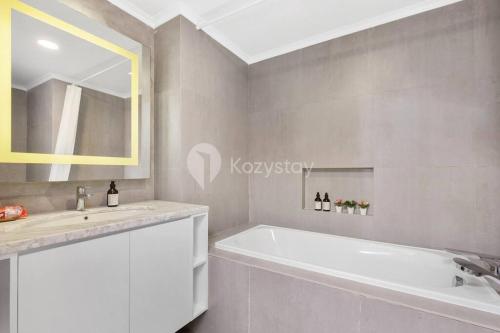 a bathroom with a white tub and a sink at VEGA by Kozystay 3BR SCBD in Jakarta