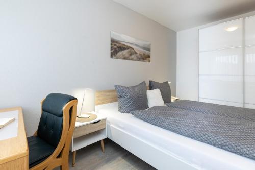 1 dormitorio con cama, escritorio y silla en Ostsee-Quartier 7 Gutenbergstraße 5 APPARTO Grömitz, en Grömitz