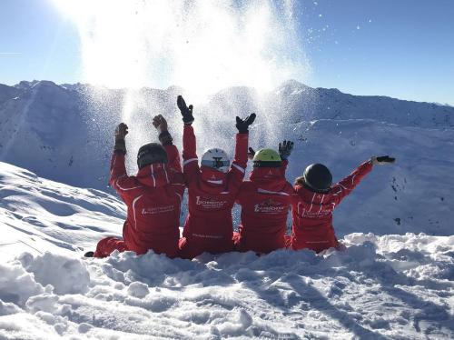 a group of people sitting in the snow at Hotel Almhof in Hochfugen