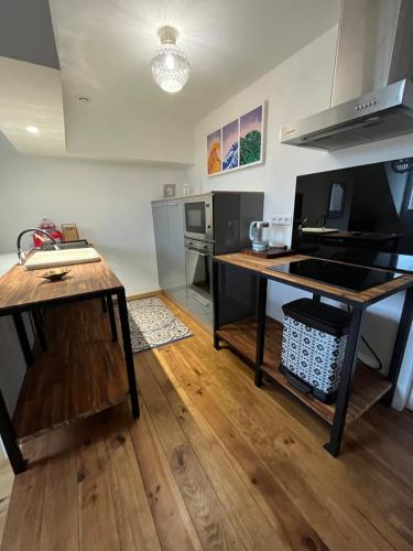 eine Küche mit einem Tisch und einer Arbeitsplatte in der Unterkunft Brive centre, superb appartement en face du Marché Primé in Brive-la-Gaillarde