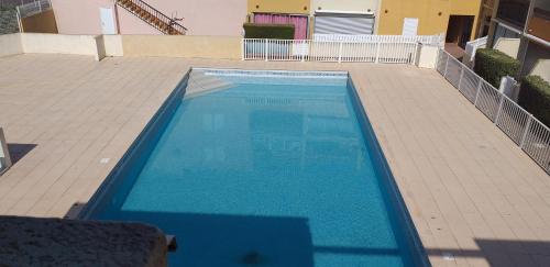 - une vue sur la piscine d'eau bleue dans l'établissement AQUAPLAGE Joli T2 piscine proche plage Richelieu AQUAPLAGE Cap d'Agde, au Cap d'Agde