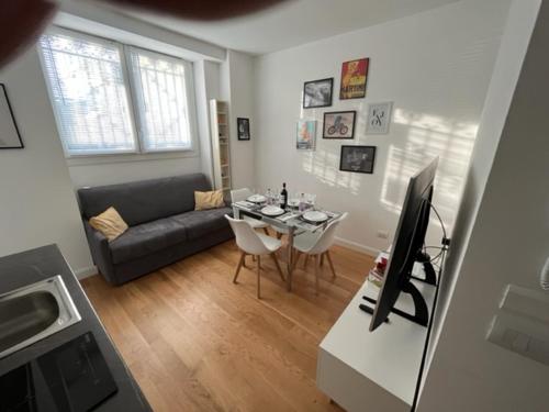 a living room with a couch and a table with a television at The Small White House In Milan in Milan