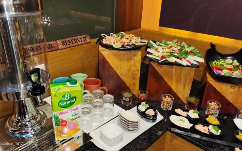 two plates of food on a counter with plates of food at Krios Hotel - Near SG Highway, Ahmedabad in Ahmedabad