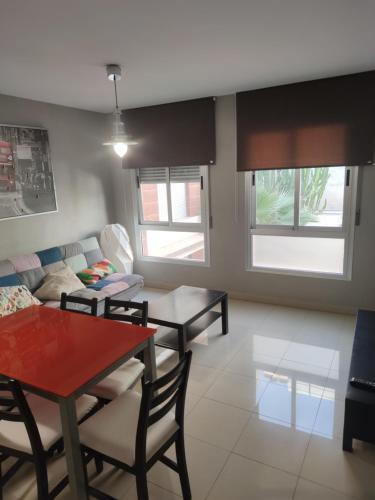 uma sala de estar com uma mesa e um sofá em Costa Tropical City em Motril