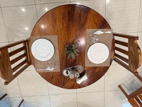 a round wooden table with two plates on it at San Pedro Country Farm Resort and Event Center Inc in Cantilan