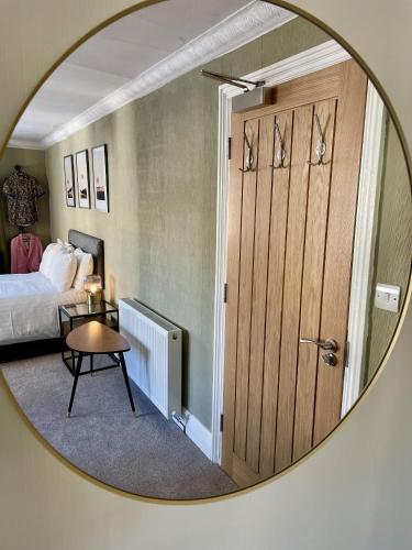 a mirror reflecting a bedroom with a bed and a table at Lacet House in Ambleside