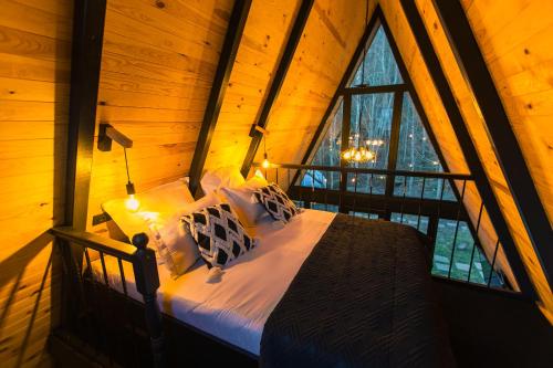 ein Schlafzimmer mit einem Bett in einem Zimmer mit einem Fenster in der Unterkunft The Palo Cabins in Predeal