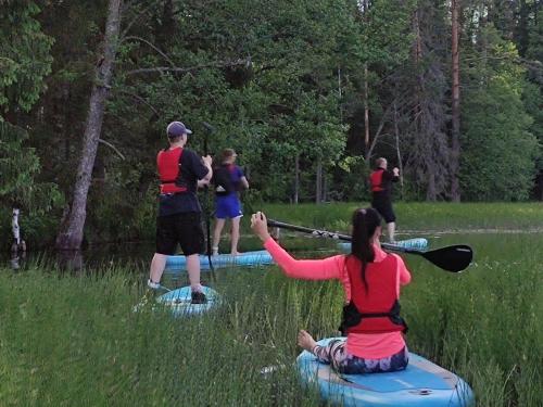a group of people on rafts in the water at Uuejärve house at Kõrvemaa forest in Pillapalu