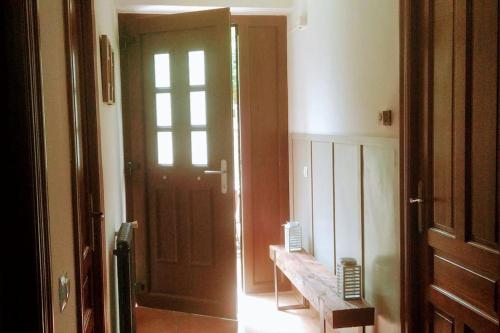 a hallway with a wooden door and a bench in a room at La casita del agua Alto Bernesga, León 