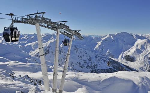 a ski lift on top of a snowy mountain at Hotel Almhof in Hochfugen