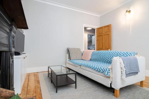 a living room with a couch and a table at Beautiful & Cosy 1-Bedroom Apartment in Clapham in London