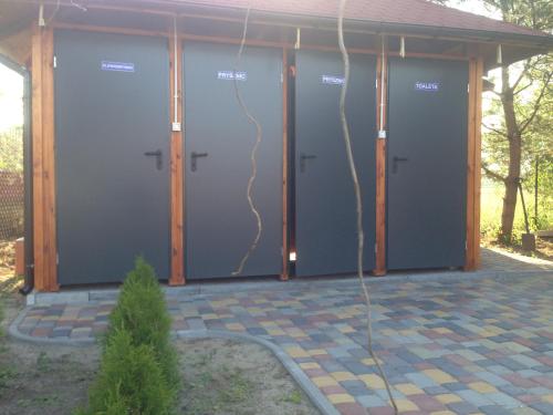 a row of four garage doors on a house at SZAŁASY drewniane nad rzeką BIEBRZA in Goniadz