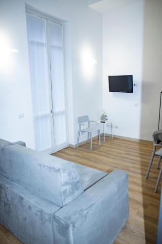 a living room with a couch and a tv at Easy Milano - Rooms and Apartments Navigli in Milan