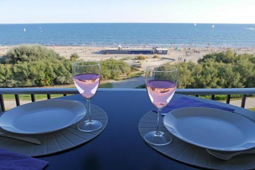 - deux verres de vin sur une table avec vue sur la plage dans l'établissement Studio de 33 m2, vue et bord de mer, parking, à La Grande Motte