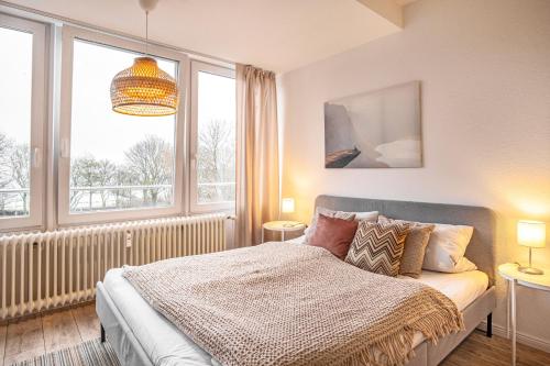 1 dormitorio con cama y ventana grande en Strandblick, en Eckernförde