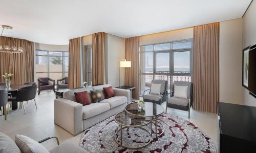a living room with a couch and a table at The Townhouses The Pearl in Doha