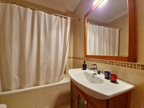 a bathroom with a sink and a shower curtain at Apartamento My Sunset T3 by YHA in Cabanas de Tavira