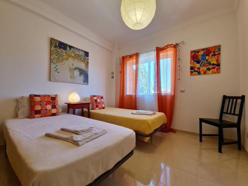 - une chambre avec 2 lits et une chaise dans l'établissement Apartamento My Sunset T3 by YHA, à Cabanas de Tavira