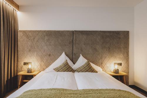 a bedroom with a large bed with two side tables at Der Gollinger in Saalbach Hinterglemm